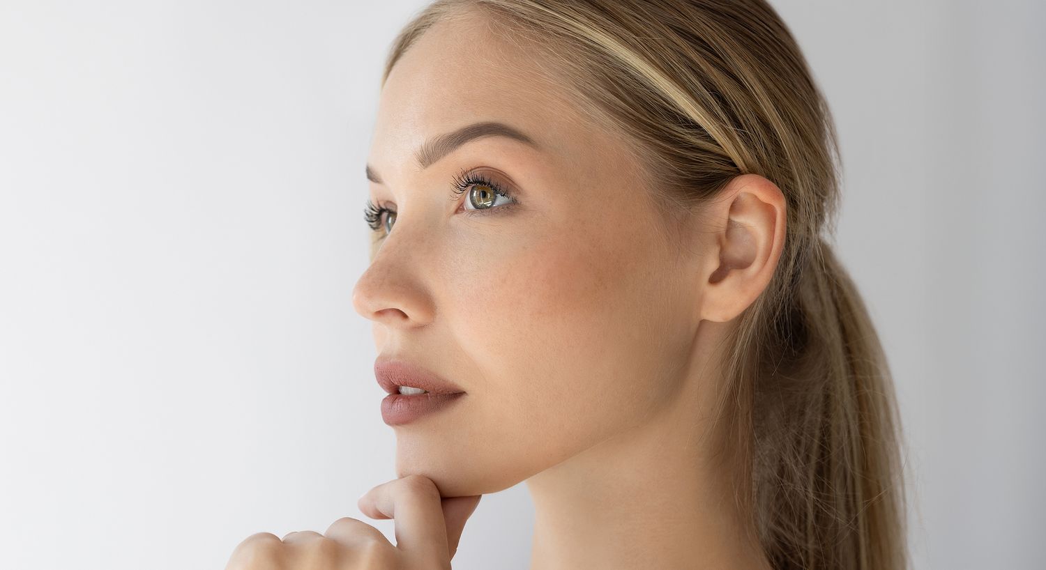 Woman in profile pondering thoughtfully.