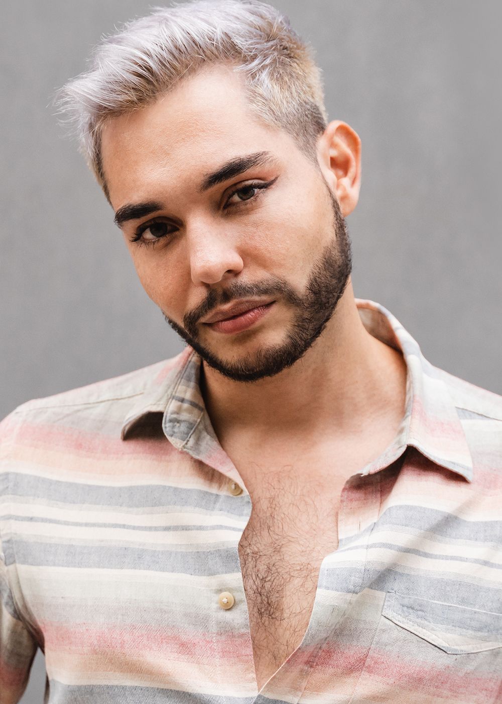 Person with stylish hair and striped shirt.