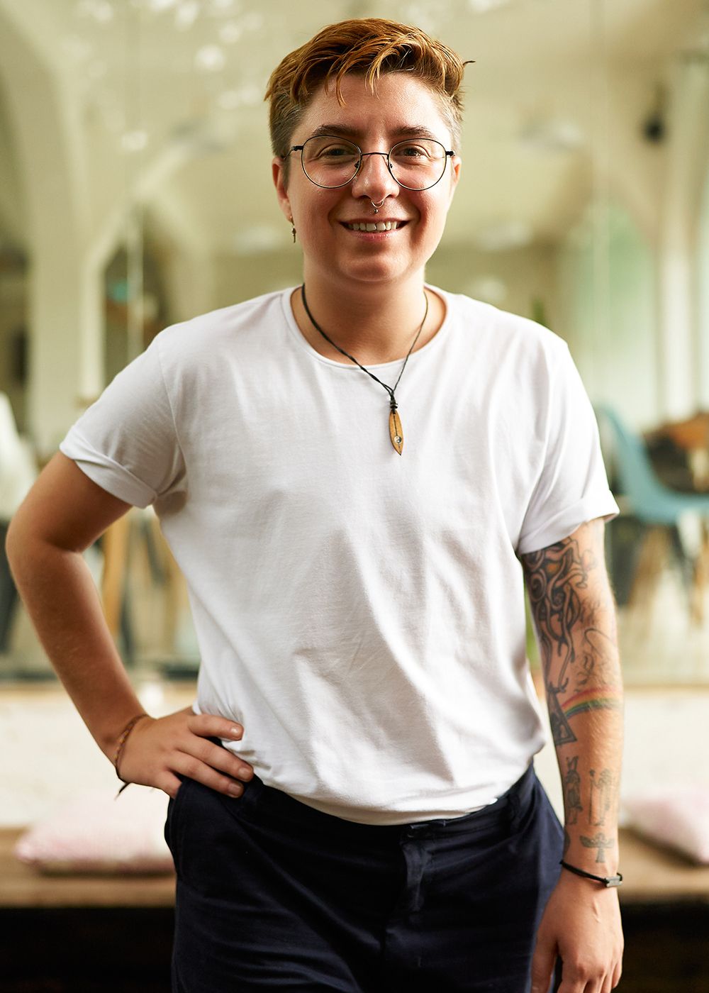 Person smiling, wearing glasses and a white shirt.